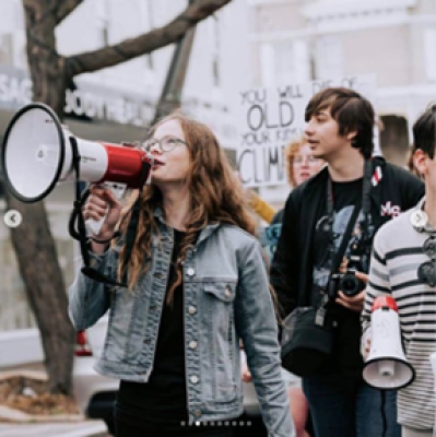 Young people protesting into a megaphone.