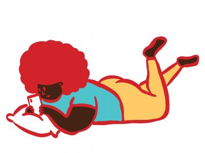 A young person lying on their stomach and smiling at their phone
