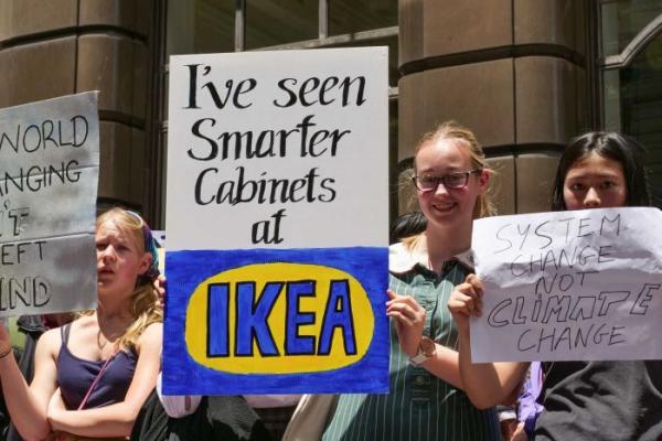 School students holding sign which says "I've seen smarter cabinets at IKEA"