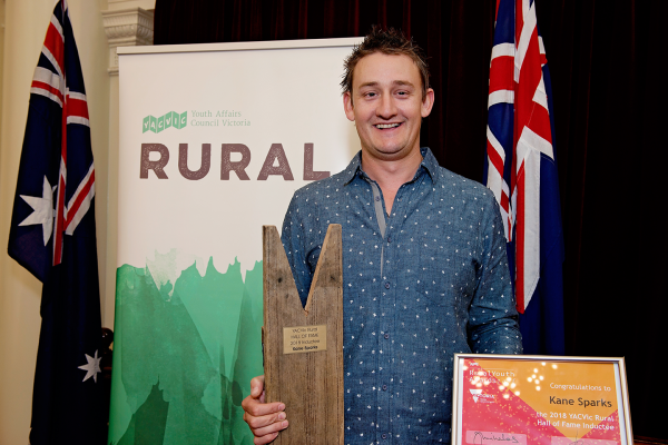 image of young person holding award at YACVic Rural Awards ceremony 