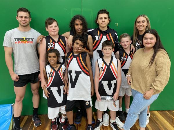 A group of smiling young Aboriginal people in sport uniforms
