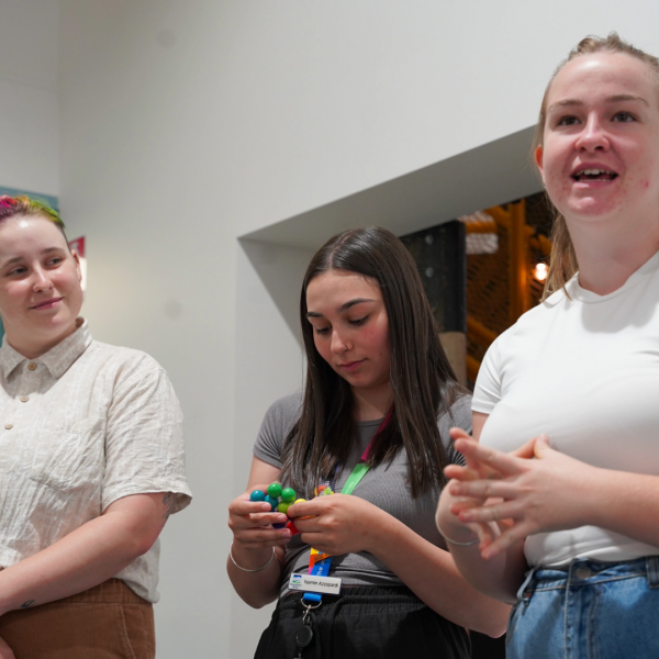 3 young people presenting, one holding a fidget toy