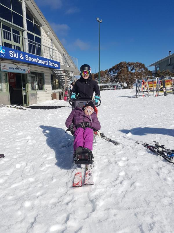 Luke on adapted ski equipment on the snow.